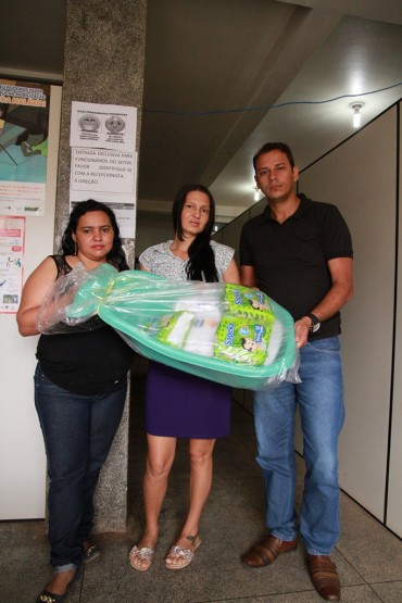 Clara Martins, Marciana Oliveira e Salustiano Freitas com o kit enxoval que é entregue às gestantes ao fim das consultas