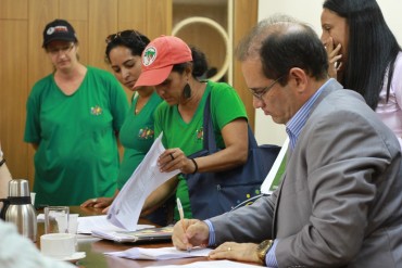 Vice-governador e líder campesina assinam a ata da reunião