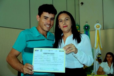Secretária Valdenice Domingos, entrega o diploma ao jovem Rogério da Costa Lesban