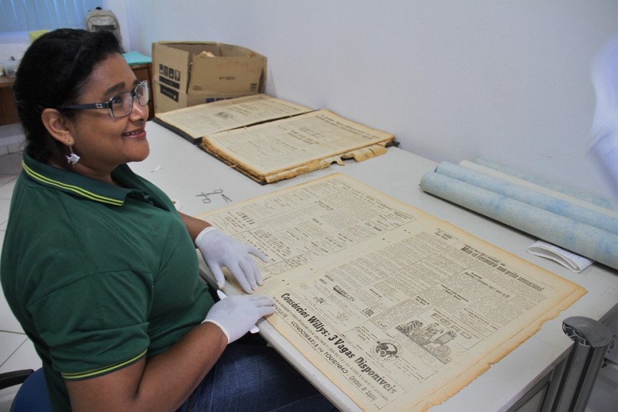 Neiva Lúcia usa fita invisível para corrigir desgaste provocado pela ação do tempo nas coleções de jornais editados em Porto Velho 