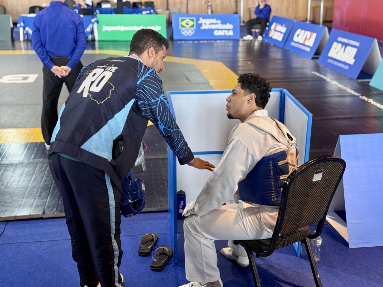 Atleta de judô recebendo orientação no intervalo da competição