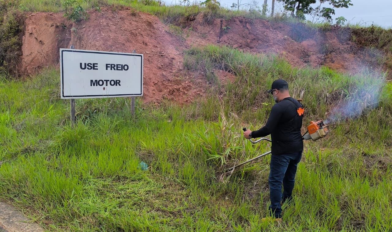 Enquanto o trator executa a roçagem mecanizada, outra equipe realiza a limpeza das placas de sinalização