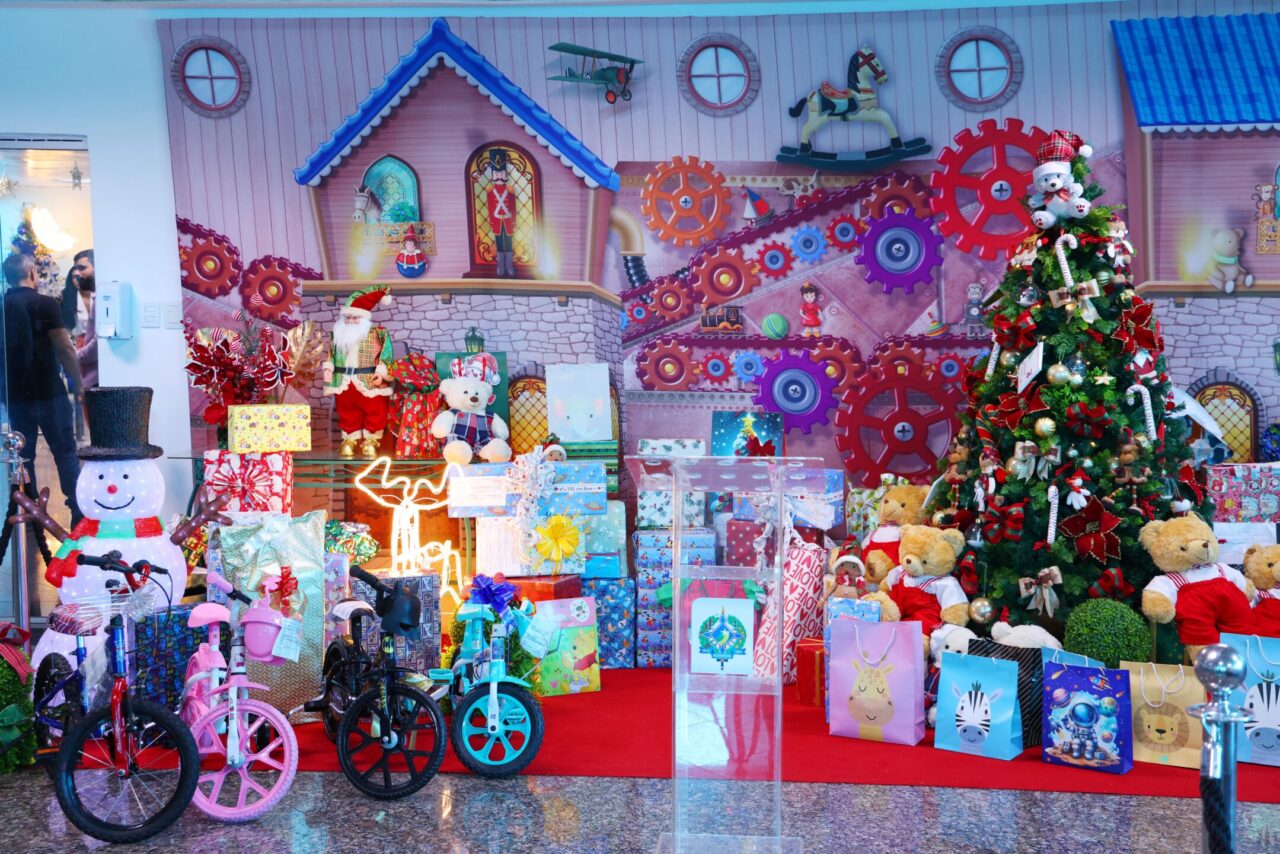 A cerimônia aconteceu em um cenário acolhedor, com Árvore de Natal, bonecas de neve e repleto de brinquedos desde bonecas a bicicletas